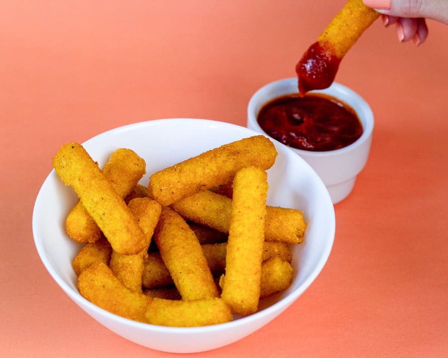 Polenta empanada com molho em fundo colorido